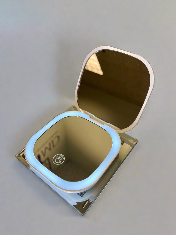 Compact travel mirror with rechargeable LED lighting and magnification