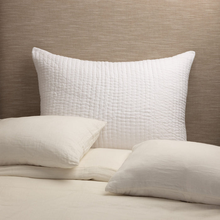 Maegan Sham styled against a neutral headboard with cream linen bedding, showcasing its texture and casual elegance. | Wildwood Home Co.