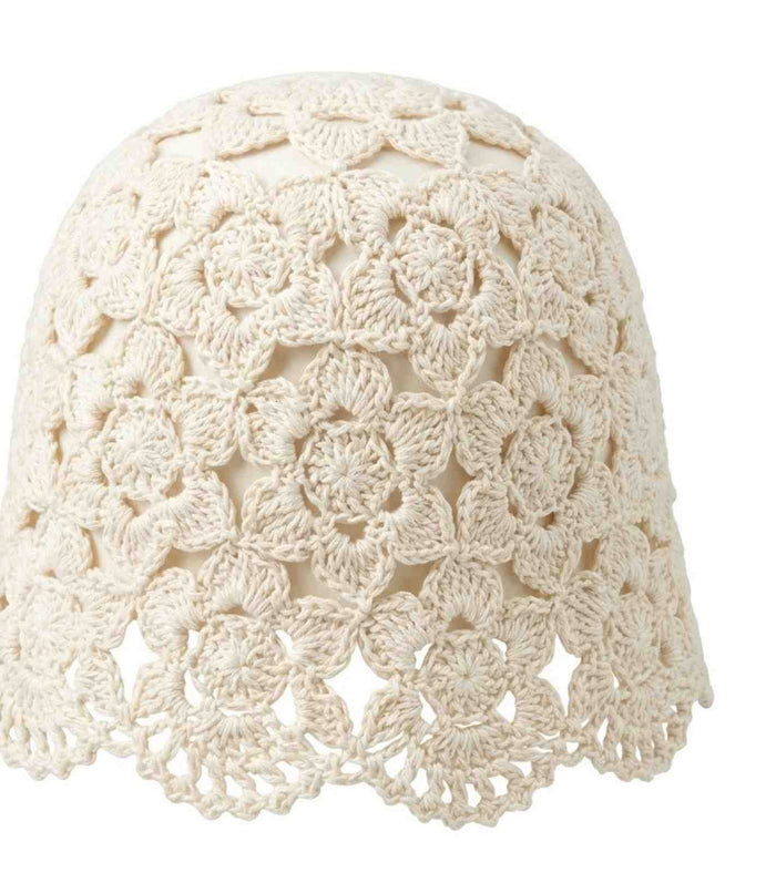Ivory crochet lace cap close-up showing floral open knit texture and scalloped top.