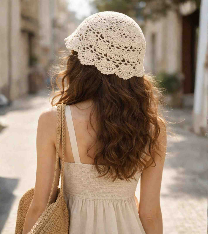 Ivory crochet lace cap from behind, open floral knit with scalloped brim edge.