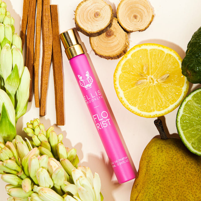Florist 10ml Eau De Parfum Travel Spray on pale pink background with lemon, lime, sandal wood, pear, flowers, and cedar wood.