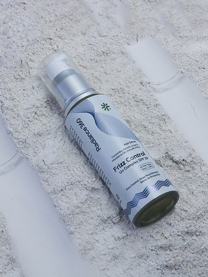 Spray bottle labeled 'Frizz Control' on a textured surface
