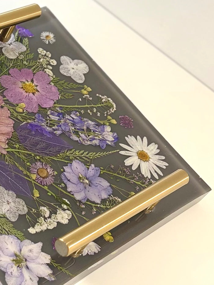 Square clear resin tray featuring a beautiful arrangement of embedded dried yellow and red flowers with metallic accent handles.