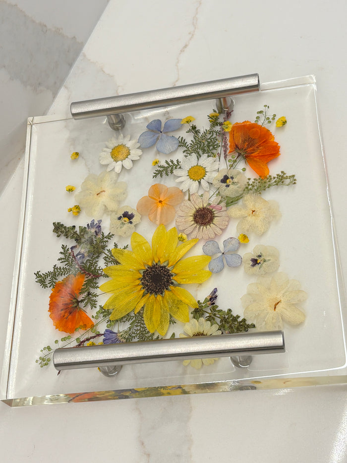 Glass shower enclosure with pressed flowers on a marble surface