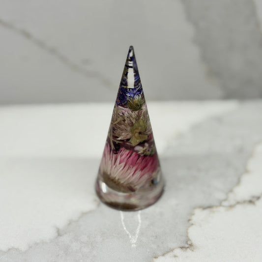 Tall, cone-shaped decorative item with floral design on a marble surface